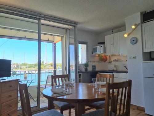 Il comprend une cuisine et une salle à manger avec une table et des chaises. dans l'établissement T2 cabine au Cap d'Agde, 4 couchages, parking privé - FR-1-249-414, au Cap d'Agde