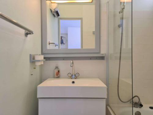une salle de bain avec un lavabo et une douche avec un miroir dans l'établissement T2 cabine au Cap d'Agde, 4 couchages, parking privé - FR-1-249-414, au Cap d'Agde