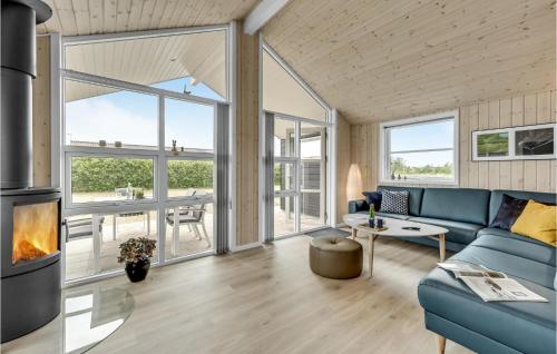 a living room with a blue couch and a fireplace at 3 Bedroom Amazing Home In Tarm in Tarm