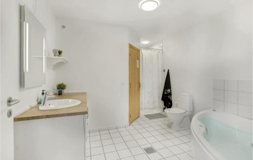 a bathroom with a sink and a tub and a toilet at Holiday Home Arvidvej Iv Denmark in Bjerregård