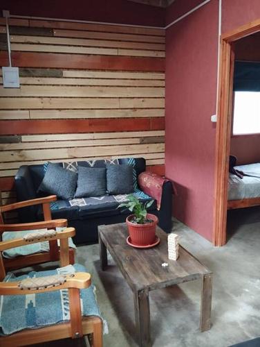 a living room with a couch and a table at Cabaña Choroy dentro del pueblo, cercano a playas in Licán Ray