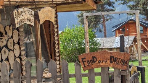 a sign on a fence in front of a house at Heshkili huts and cabins Svaneti in Keshkili