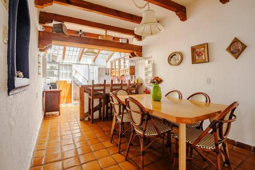 a kitchen and dining room with a wooden table and chairs at Casa Aimée in Mexico City