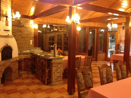 a kitchen with a fireplace and a table and chairs at Vándor Vigadó in Zalaegerszeg