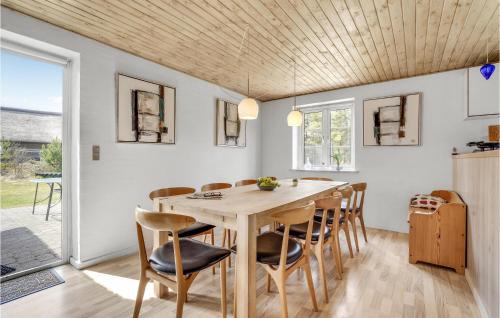 a kitchen and dining room with a wooden table and chairs at Four-Bedroom Holiday Home In Romo in Rømø