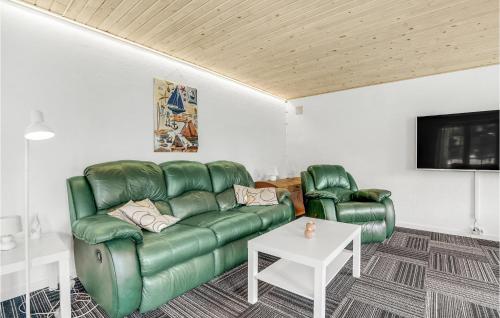 a living room with a green couch and two chairs at Four-Bedroom Holiday Home In Romo in Rømø