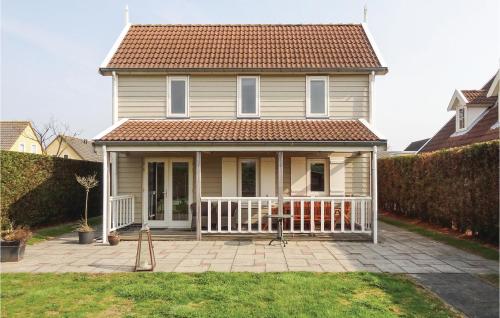 a house with a porch and a white fence at 3 Bedroom Stunning Home In Wemeldinge in Wemeldinge