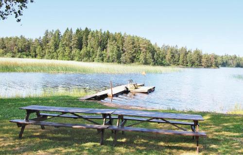 a picnic table and a dock on a lake at 2 Bedroom Beautiful Home In Linneryd in Linneryd