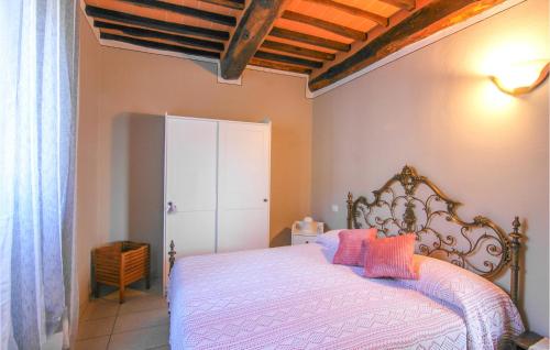 a bedroom with a white bed with pink pillows at Awesome Home In Macchino With Kitchen in Marliana