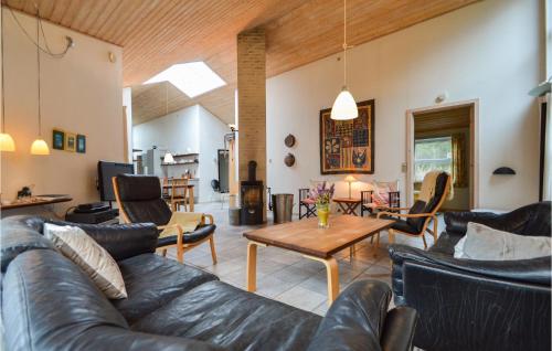 a living room with leather couches and a table at Holiday Home Granvej Rømø Ii in Bolilmark