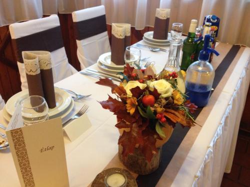 a table with a vase of flowers and wine bottles at Vándor Vigadó in Zalaegerszeg