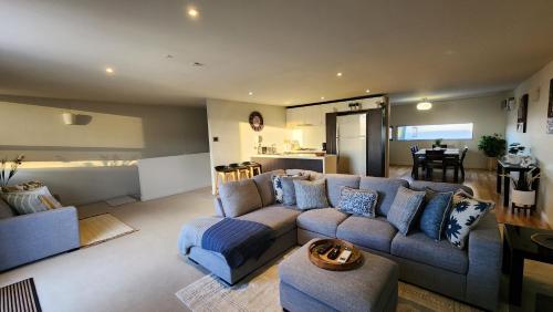 a living room with a blue couch and a kitchen at Number 9 on Cataract in Launceston