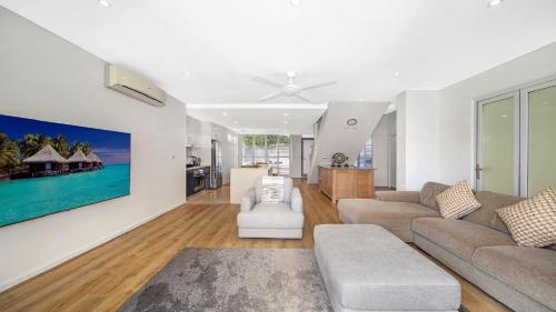 a living room with a couch and a table at Ettalong Beach - Poolside Luxury in Ettalong Beach