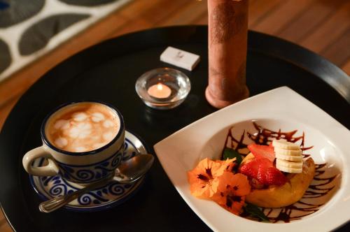 a black plate with a cup of coffee and a plate of food at Petit Mesón (Pet Friendly Hotel) in Valle de Bravo