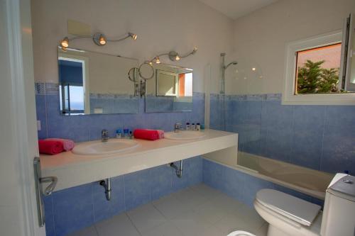 a bathroom with two sinks and a mirror and a toilet at Mar Bona in Tamariu