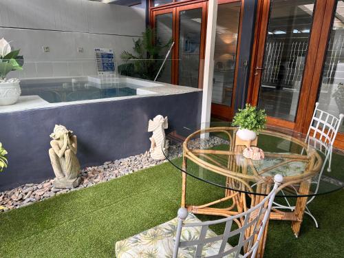 a patio with a glass table and chairs in front of a building at Beachside 2 with Private Heated Plunge Pool in Port Douglas