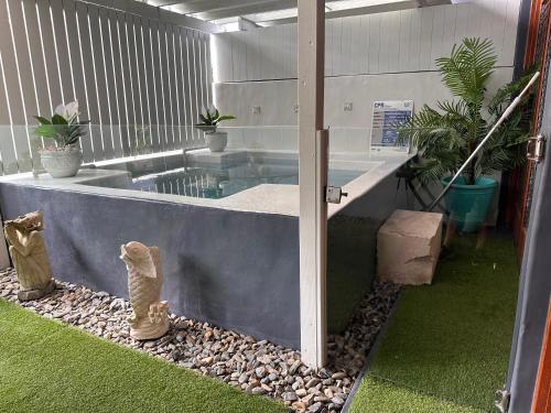 a room with a swimming pool and a patio with plants at Beachside 2 with Private Heated Plunge Pool in Port Douglas