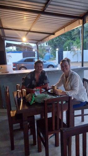 two people sitting at a table in a restaurant at Hotel white house mahiyanganaya in Mahiyangana