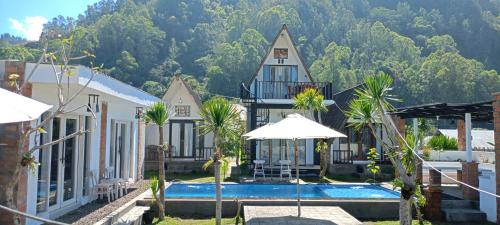 a house with a swimming pool in front of a mountain at Batur Homestay and Lodge in Bangli