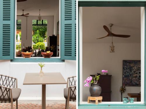 a dining room with blue shutters and a table at PHA NYA RESIDENCE in Luang Prabang