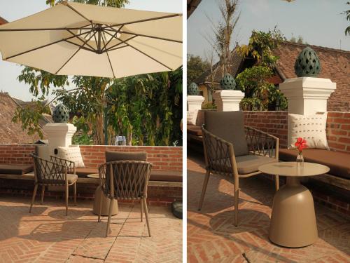 a table and chairs and an umbrella on a patio at PHA NYA RESIDENCE in Luang Prabang