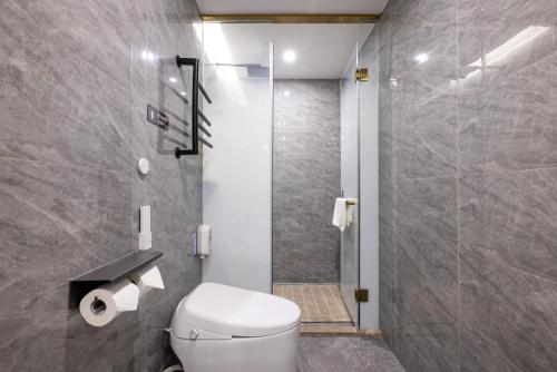 a bathroom with a toilet and a shower at Nostalgia S Hotel Beijing National Convention Center 时光漫步S酒店北京国家会议中心店 Free fresh ground coffee,Free laundry service in Beijing