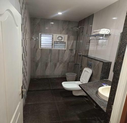 a bathroom with a toilet and a sink at NavaRATNA Delight in Coimbatore