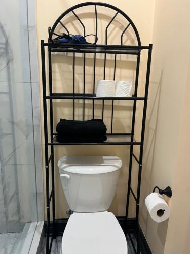 a bathroom with a toilet and a shelf with towels at The Grassy Oasis in Brampton