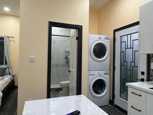 a bathroom with a washer and dryer in a room at The Grassy Oasis in Brampton