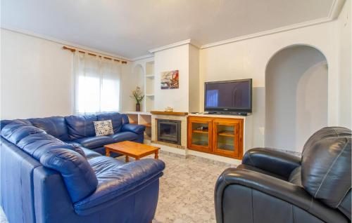 a living room with two blue couches and a tv at Amazing Home In Gran Alacant in Santa Pola