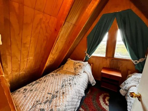une chambre avec un lit dans une pièce avec une fenêtre dans l'établissement Cabañas Linda Vista, à Cucao