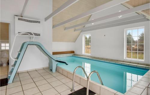 a swimming pool with a slide in a building at Cozy Home In Rømø With Sauna in Kongsmark