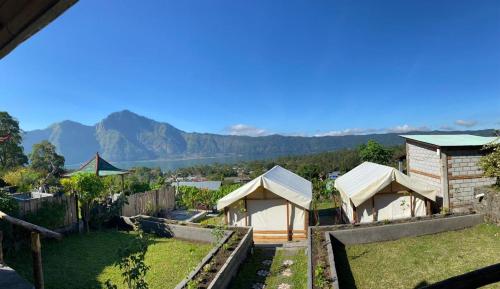 a view of a house with mountains in the background at Black Lava Hostel and Lodge in Kintamani