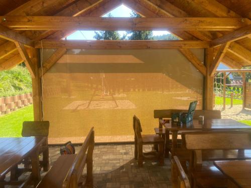 a patio with wooden tables and chairs and a basketball court at Chata U dědka in Prostřední Bečva