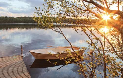 a boat sitting on the water next to a dock at Nice Home In Gislaved With Sauna in Våthult