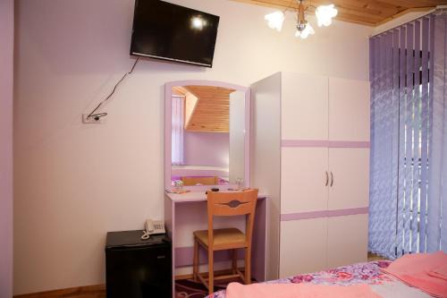 a bedroom with a desk and a chair and a mirror at Stanchevata Kashta in Zlatograd