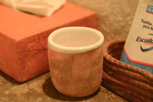 a cup sitting on a table next to a basket at Mesón De Leyendas Breakfast & Downtown in Valle de Bravo