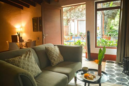 a living room with a couch and a table at Mes&oacute;n De Leyendas Breakfast & Downtown in Valle de Bravo