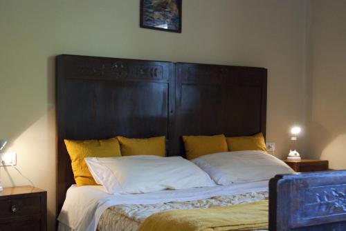 a bed with a large wooden headboard in a bedroom at Agriturismo Bosco Del Fracasso in Scandiano