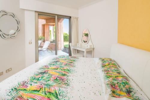 a bedroom with a large bed with a colorful blanket at Bahia de los Menceyes Heated Pools in Palm-Mar