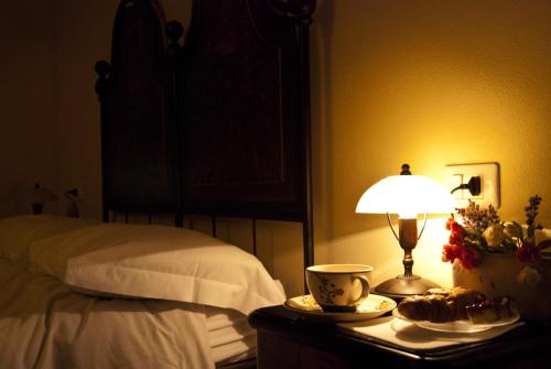 a bedroom with a bed and a table with a lamp at Agriturismo Bosco Del Fracasso in Scandiano