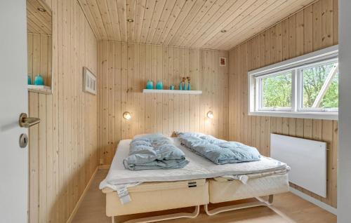 a bedroom with a bed with blue pillows on it at Holiday Home Blåbærvænget Humble Vi in Humble