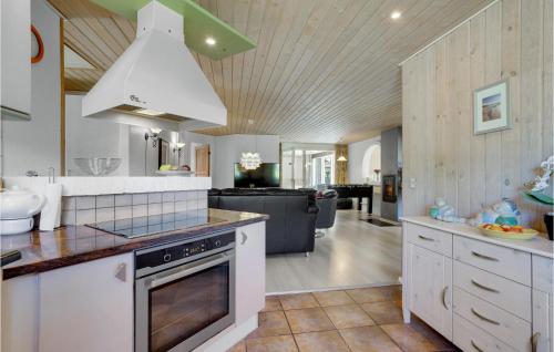a kitchen with a stove top oven next to a living room at Awesome Home In Løgstør With Sauna in Trend