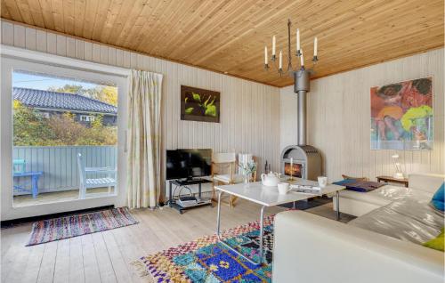 a living room with a couch and a table and a tv at Holiday Home Tyr-Holmen in Gilleleje