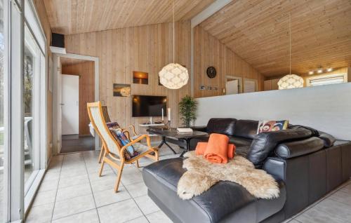ein Wohnzimmer mit einem Ledersofa und einem Tisch in der Unterkunft Beautiful Home In Oksbøl With Sauna in Oksbøl