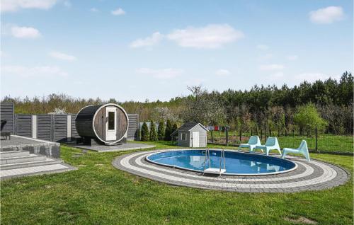 a backyard with a pool with chairs and a house at Nice Home In Gniewino With Kitchen in Gniewino