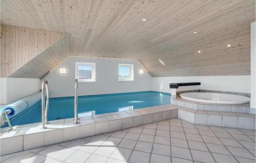 a large bathroom with a tub and a sink at Cozy Home In Hvide Sande With Sauna in Bjerregård