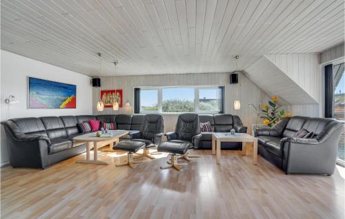 a living room with leather couches and tables at Cozy Home In Hvide Sande With Sauna in Bjerregård