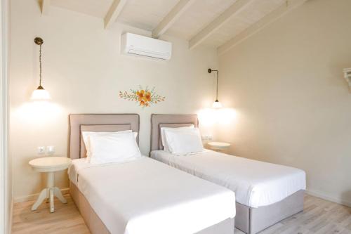 two beds in a room with white walls at Teacher's House in Meganisi