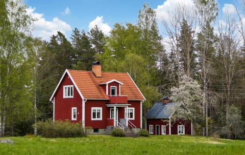 ビンメルビューにあるGorgeous Home In Vimmerby With Kitchenの木の集まる野原の赤い家